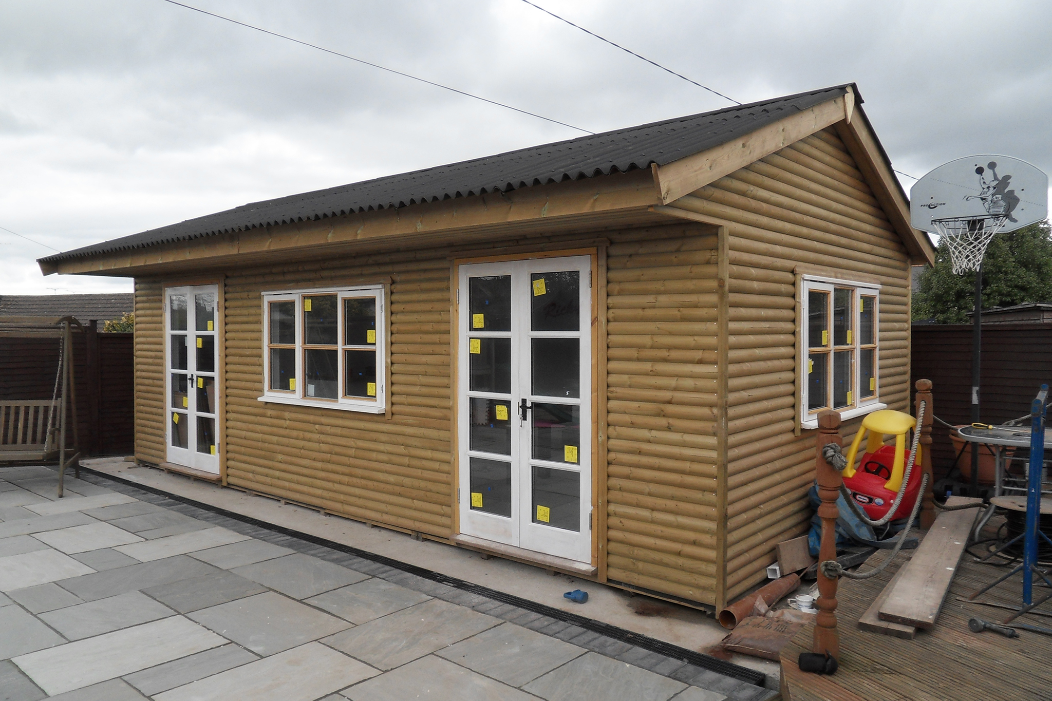 Log lap clad Office, with PVC windows and doors, topped with a Black corrugated Onduline Roof - Harris Timber Products