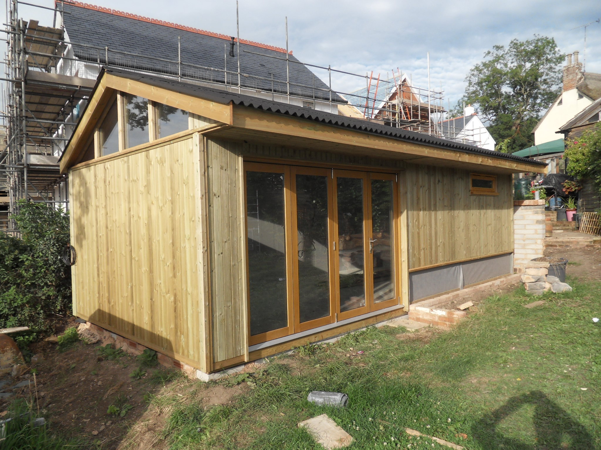 Vertically clad Western Red Cedar, with bi fold double glazed doors and topped with a Black corrugated Onduline Roof - Harris Timber Products